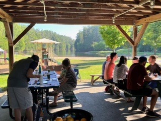 GME Hospice & Palliative Medicine fellows grouped at two picnic tables.
