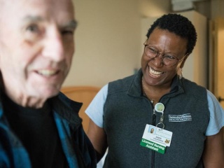 UVMMC Home Health and Hospice LNA smiling with patient.
