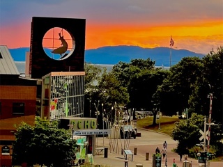 Exterior of ECHO Museum with brilliant sunset behind it over lake and mountains