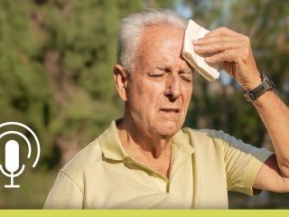 Older man patting sweat on his forehead with a hankerchief.