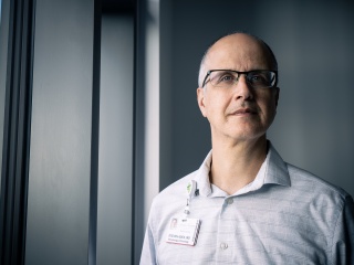 Portrait of Steven Ades, MD standing next to a window.