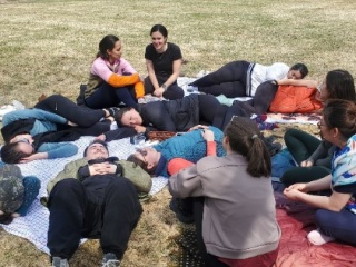OBGYN residents lounge outside in the grass.