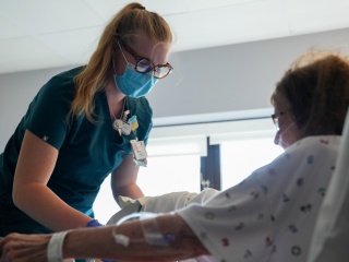 Izzy Paquette therapy aide helping a patient in their exam room.