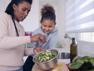 an adult and child cooking together 