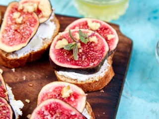 Walnut fig goat cheese bread appetizer sits on a cutting board.