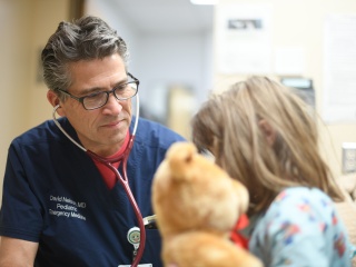 Doctor David Nelson care for pediatric child patient in the emergency department.