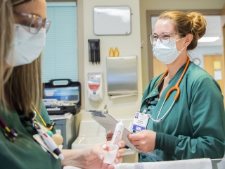 A female travel nurse smiles while working at the hospital.