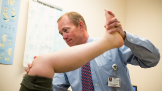 Doctor gives orthopedic knee therapy to a patient.