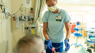 Cancer Center nurse takes patient's pulse 