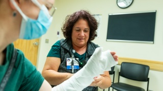 A University of Vermont Medical Center medical assistant wraps a patient arm at Urgent Care in Colchester.