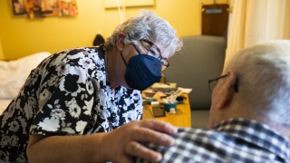 A nurse speaks with a resident.
