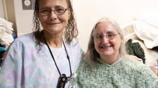A medical provider and a resident pose for a photo.