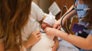 A nurse checks a newborn baby.