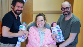 A family holds their newborn twin babies.