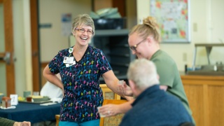 Employees and residents at CVMC Woodridge Rehabilitation & Nursing smile and laugh.