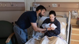 A family cuddles their newborn baby in the Alice T. Miner Women & Children's Birthing Center at Champlain Valley Physicians Hospital.