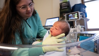 A Champlain Valley Physicians Hospital nurse holds a newborn in the Alice T. Minter Women & Children's Center.