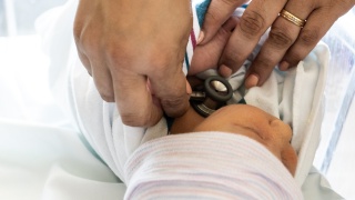 Close of up of UVM Medical Center staff member's hands as she cares for newborn.