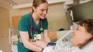 Nurse checks blood pressure on patient in hospital.