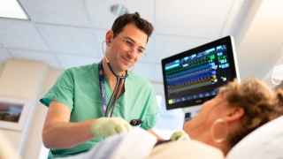 Doctor examines patient in the ICU at Champlain Valley Physicians Hospital.