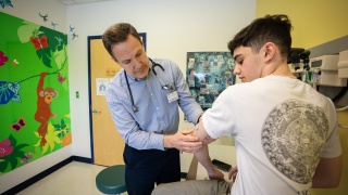 A medical provider checks a patient's arm.