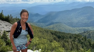 Amanda Gibbs trail running at the summit of a mountain.