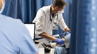 A doctor examines a patient's leg in the Emergency Department at UVM Medical Center.