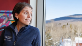 Rebecca Bell, MD, looks out a window from her office.