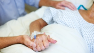 Person holding patients hand in the hospital.
