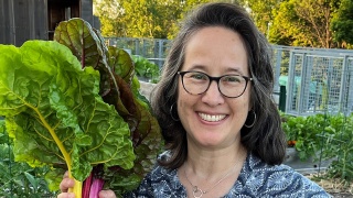 Rachel Boyers holding a bunch of vegetables from her garden.