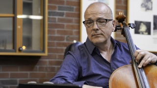Portrait of Denis Thibouthot playing cello.