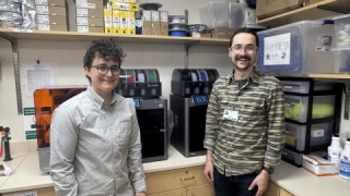 Laura Mulvey, MD and Miles Lamberson pose in front of 3d printers at UVM Medical Center