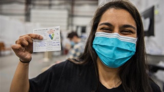 A patient holds up a vaccination card.