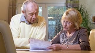 An older couple reviewing paper documents
