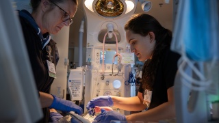 Two medical providers work in the NICU.