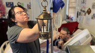 Kelly McGuire cares for her brother, Shaun McGuire, at their home.