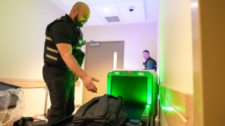 A security officer scans a bag.