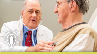 David Schneider, MD, examines a patient with a stethoscope.