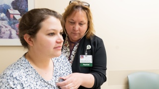 A medical professional listens to a patient's heart.