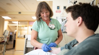 A cancer center provider checks a patient.