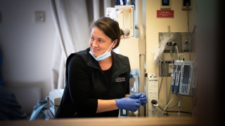 A medical professional smiles at something in the distance.