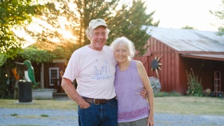 Norton and Marlene Latourelle pose for a photo in front of their barn.