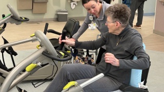A rehab therapist assists a patient.