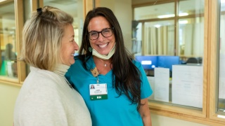 Two medical providers smile at each other.