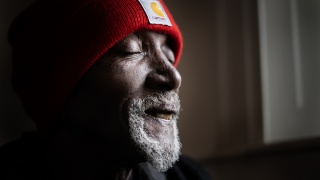 Portrait of patient Darrell Fields wearing a red hat.