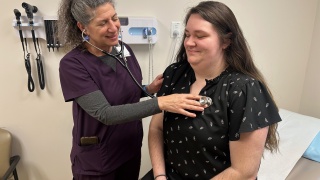 A medical provider checks a patient's heartbeat.