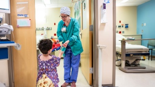 A Child Life Specialist at Golisano Children's Hospital talks with a pediatric patient.