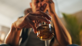 Stock photo of adult holding a glass of alcohol.
