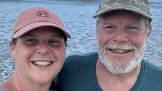 Mike and Kate Spaeder pose for a photo by the lake.