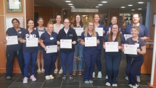 A group of nurse residency grads poses with their certificates.